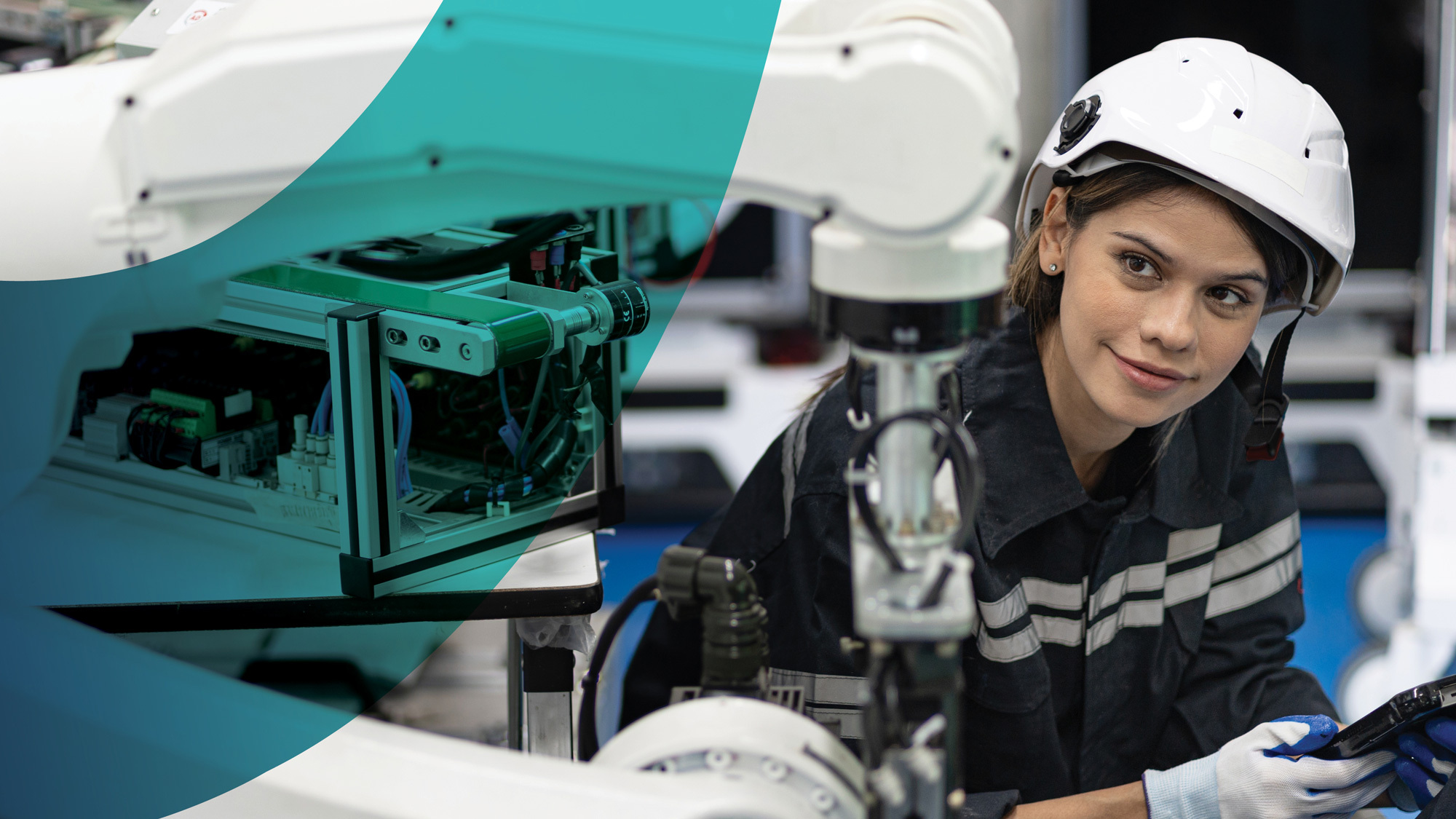 An engineer wearing a white safety helmet controls a robotic machine that sits to the persons rights, representing a PhD candidate for the National Industry PhD program.